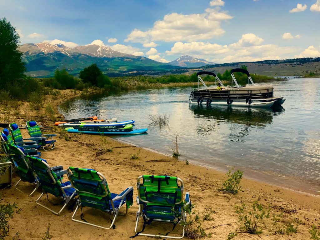 Sandy beach at Twin Lakes with pontoon boat and paddlboards